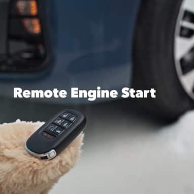2027 Honda Odyssey Elite detail of the remote engine start key fob held by a person in a winter glove (Minivan).